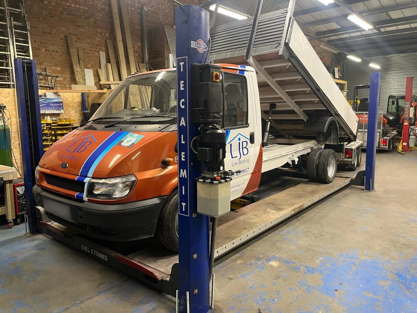 An LJB tipper truck on the four-post lift in the Pear Tree Garage workshop